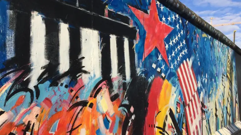 Die Berliner Mauer mit künstlerischen Graffitis unter einem strahlend blauen Himmel in Berlin.