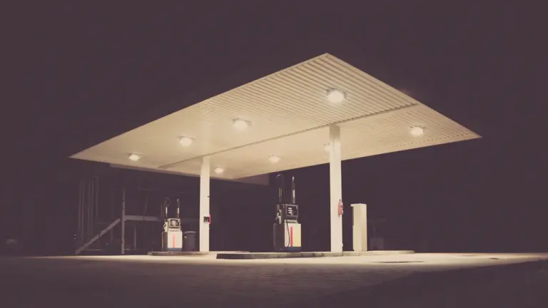 Eine nächtliche Tankstelle in Deutschland mit beleuchteten Zapfsäulen und Werbetafeln.