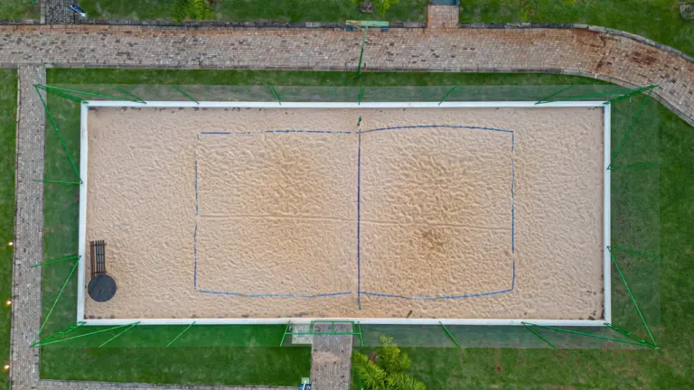 Luftaufnahme eines leeren Beach-Tennis-Spielfeldes in einem sonnigen Park im Sommer.