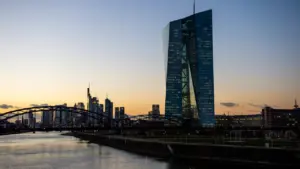 Blick auf das EZB-Gebäude und die Frankfurter Skyline bei Sonnenuntergang über dem Main.
