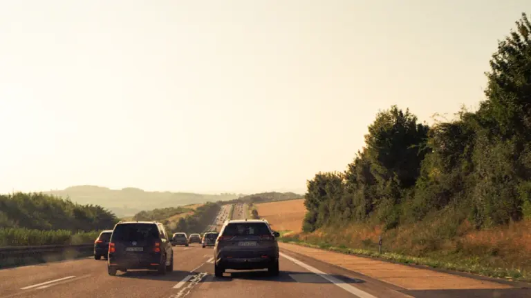 Autos fahren auf einer Autobahn Richtung Hügellandschaft am Ende der Sommerferien.