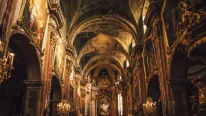 Prunkvoller Innenraum einer historischen Kirche mit goldenen Verzierungen und kunstvoller Architektur.
