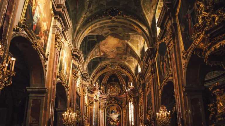 Prunkvoller Innenraum einer historischen Kirche mit goldenen Verzierungen und kunstvoller Architektur.