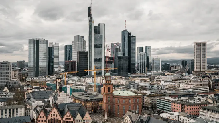 Die Frankfurter Skyline mit der historischen Paulskirche im Vordergrund an einem sonnigen Tag.