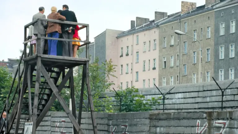 Menschen auf einer hölzernen Aussichtsplattform an der Berliner Mauer im Jahr 1974.