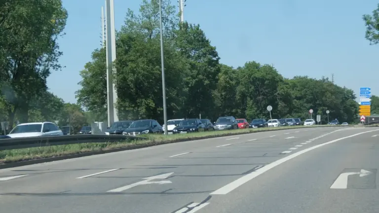 Autos stehen im dichten Stau auf einer deutschen Landstraße am sonnigen Nachmittag.