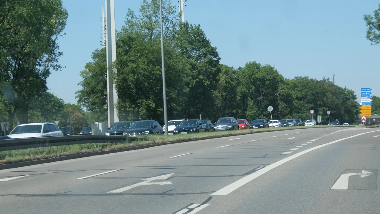 Autos stehen im dichten Stau auf einer deutschen Landstraße am sonnigen Nachmittag.