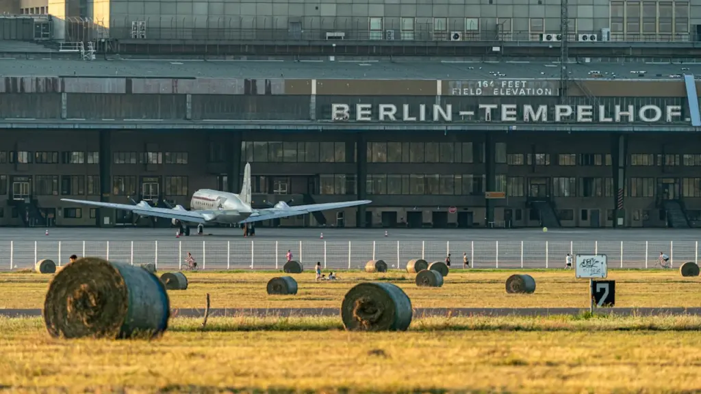 Historisches Flugzeug auf dem Rollfeld des ehemaligen Flughafens Berlin-Tempelhof bei Sonnenuntergang.