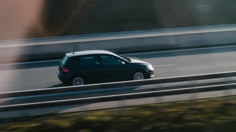 Ein dunkler Pkw fährt mit moderater Geschwindigkeit auf einer deutschen Autobahn.