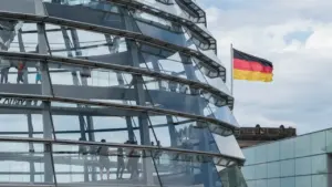 Die gläserne Kuppel des Reichstagsgebäudes in Berlin unter einem bewölkten Himmel.