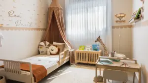 Ein gemütlich eingerichtetes Kinderzimmer mit Bett und Schreibtisch in hellen, warmen Farbtönen.