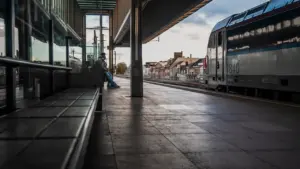 Ein einsamer Reisender wartet an einem verlassenen Bahnsteig bei Dämmerung.