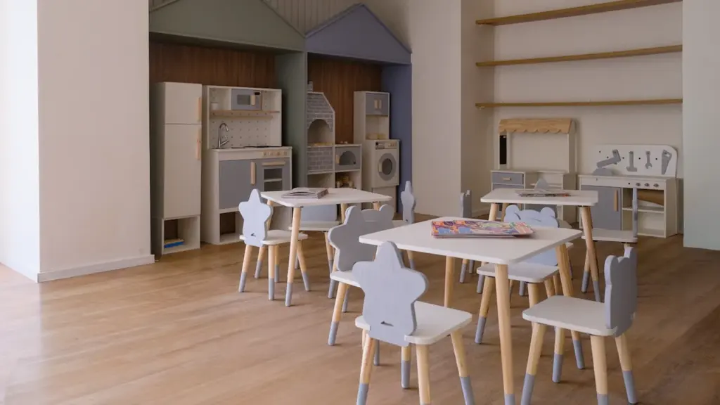 Heller Lernbereich mit kleinen Kindertischen und Stühlen für pädagogische Aktivitäten im Klassenzimmer.