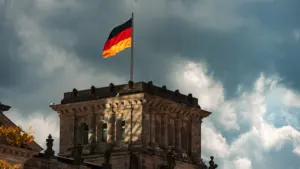 Die deutsche Flagge weht über dem historischen Gebäude unter einem bewölkten Himmel.